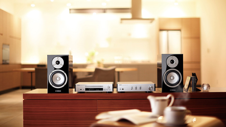 Compact hi-fi amplifier and bookshelf speakers placed in a small living space