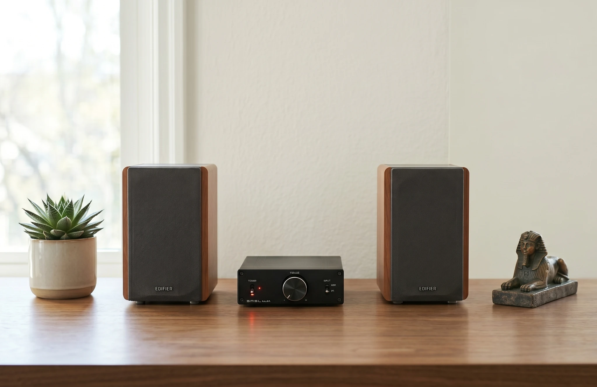 Budget stereo amplifier under $100 paired with bookshelf speakers in a clean home audio setup