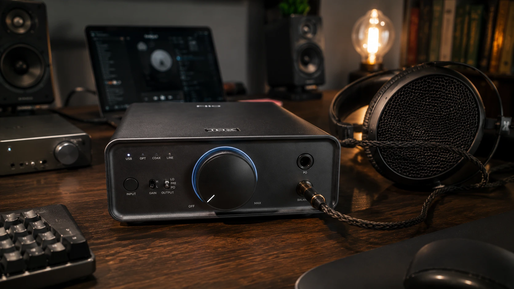 FiiO K7 balanced desktop DAC headphone amplifier on a home audio desk with 4.4mm Pentaconn balanced headphone cable connected