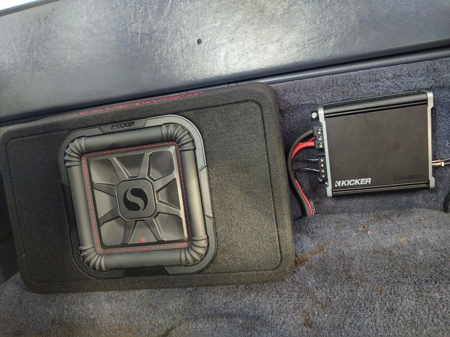 Kicker 46CXA800.1 amplifier installed in a car trunk with subwoofer